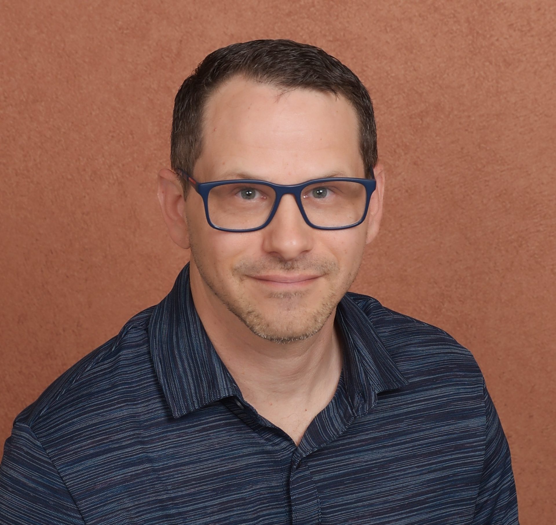 Man with glasses and blue shirt